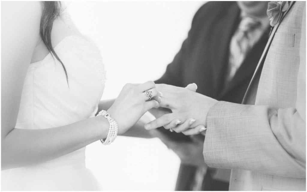 Bride slips a ring on the groom's finger during their wedding ceremony at Star Hill Ranch.