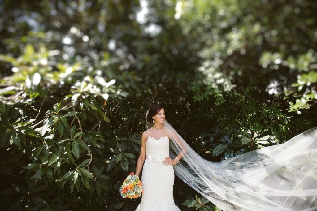 A bride's veil blows in the wind during her bridal portrait photo session at Laguna Gloria.