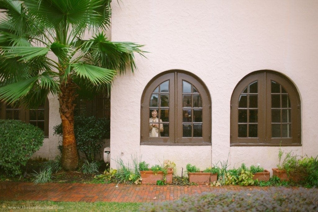 The mother of the bride looks out the window to watch her daughter getting ready for her wedding.
