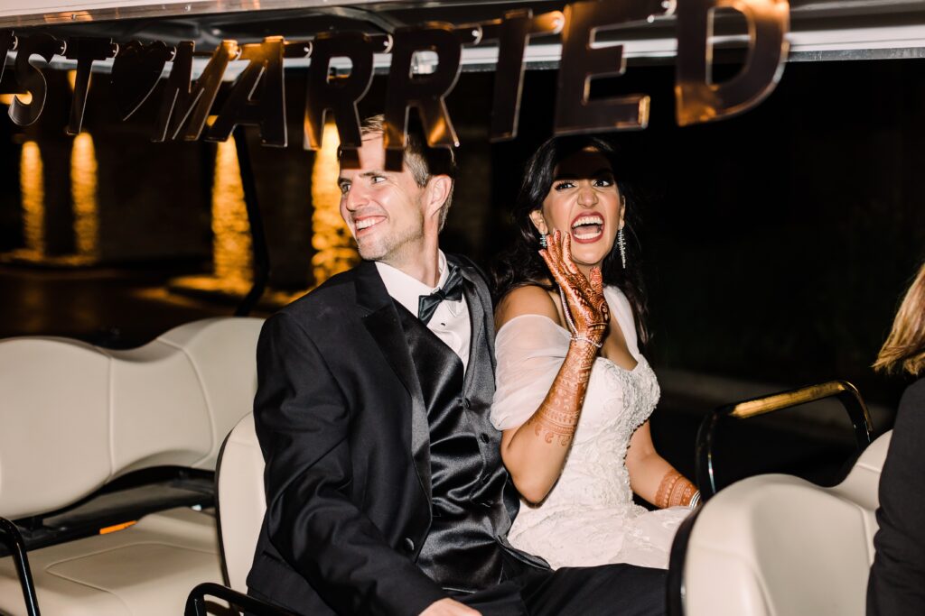 Bride and groom waving from golf cart grand exit as part of a Lakeway Resort wedding
