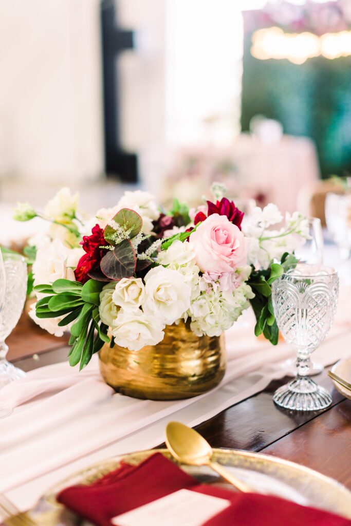 Flowers in gold vase on Maes Ridge wedding reception table