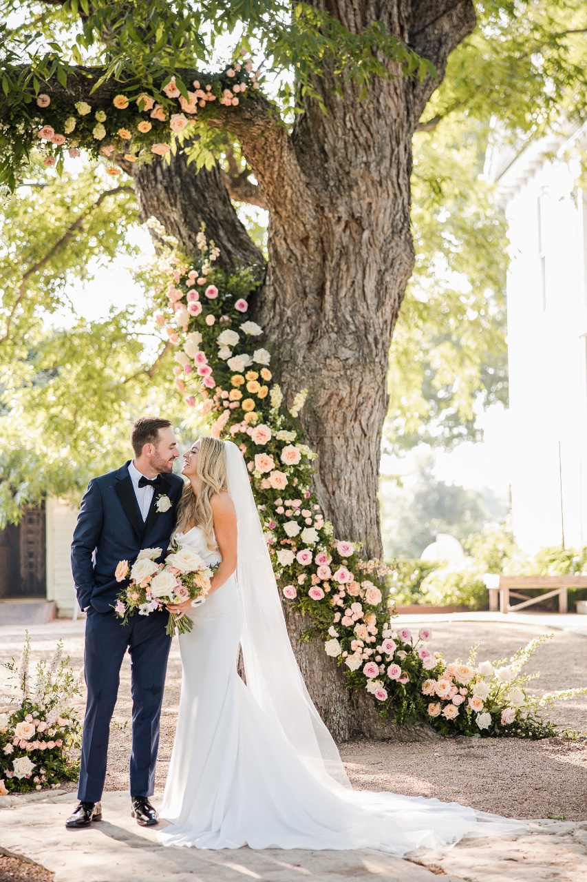 Couple kissing under oak trees at Barr Mansion Austin wedding