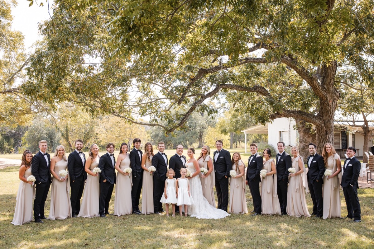 Pecan Springs Ranch wedding ceremony arch decorated with flowers and greenery