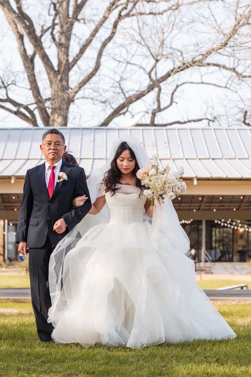 Bride L and groom M kiss as newlyweds at Pecan Springs Ranch