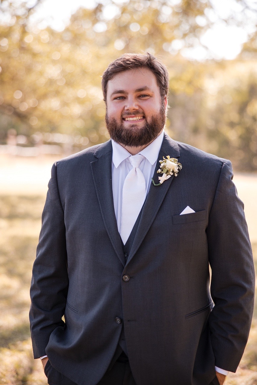 Groom D preparing for ceremony in vintage ranch style at Old Glory Ranch