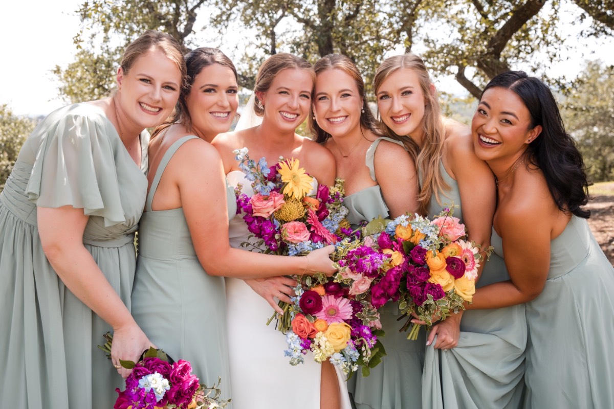 A and M exchanging vows under the oak trees at their Dripping Springs Hill Country wedding