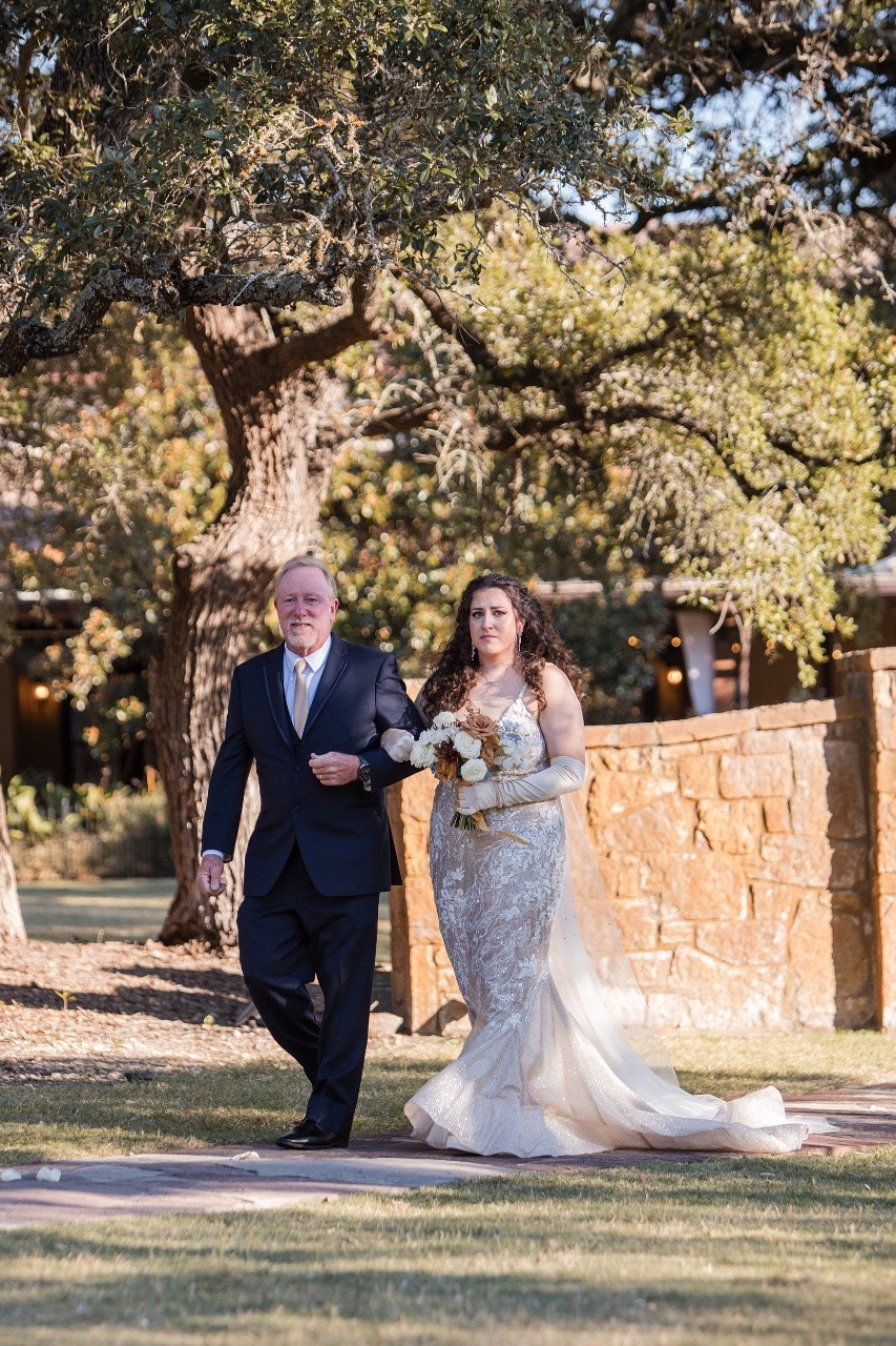 C and C exchanging vows under rustic wooden arch at fall wedding