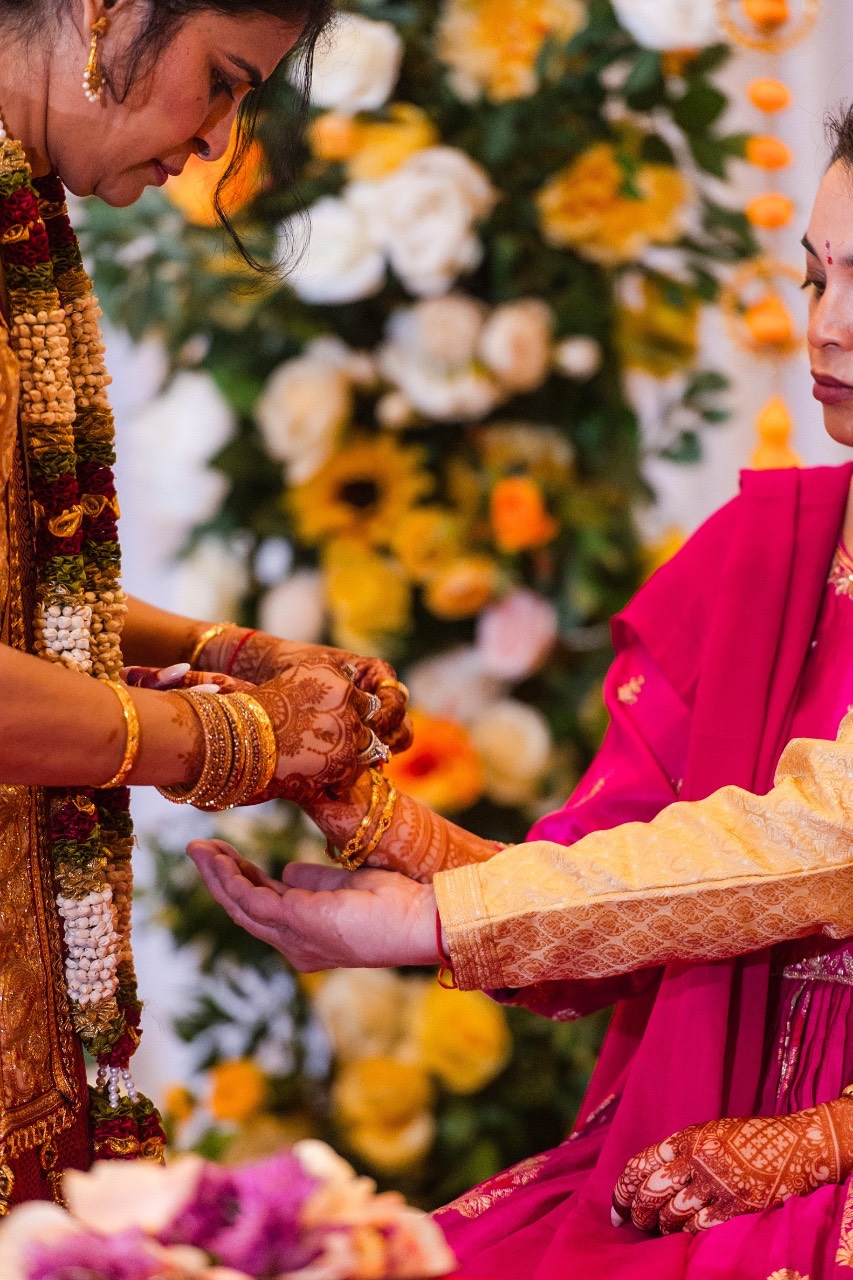 Groom sliding ring onto bride's finger at Austin wedding ceremony