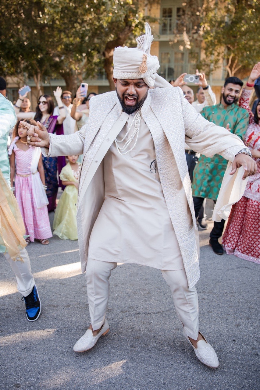 A walking down aisle toward groom at Hyatt San Antonio