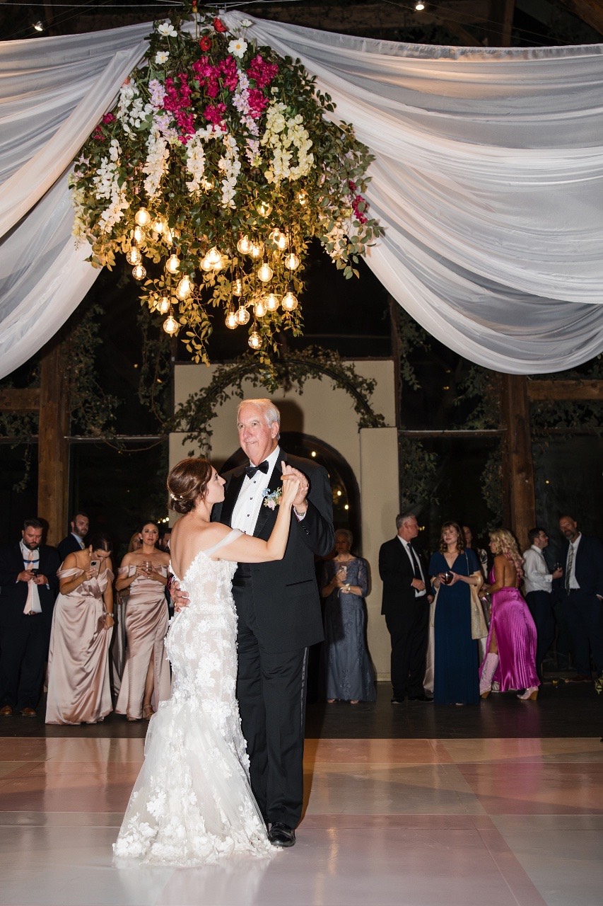 Groom S holding bride L's hands during first look at venue