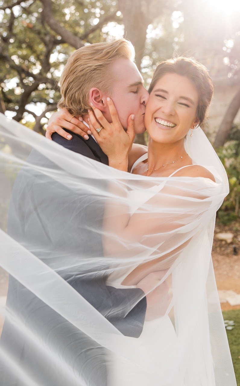 Bride and groom posing with scenic Marble Falls backdrop at Balcones Springs
