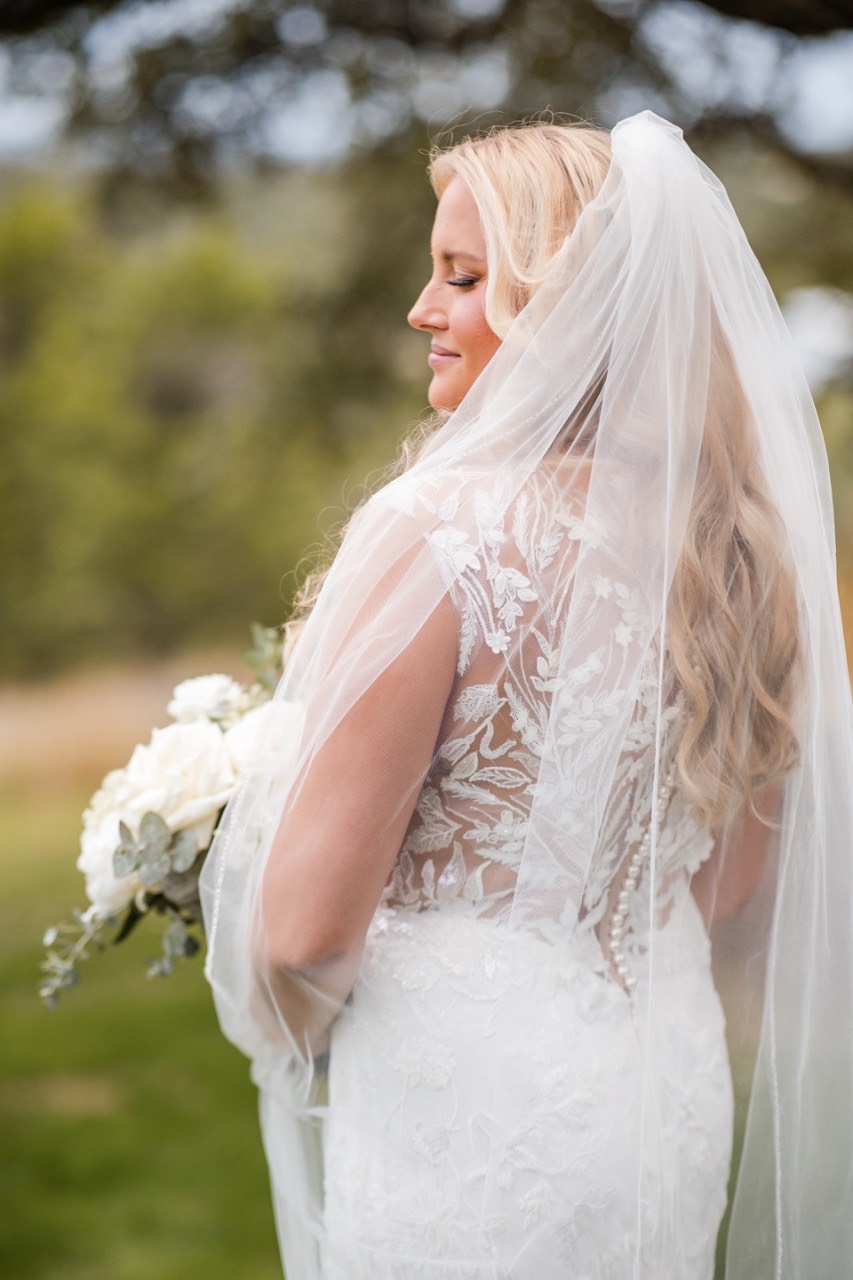 Bride placing ring on groom's finger at Canyonwood Ridge outdoor wedding