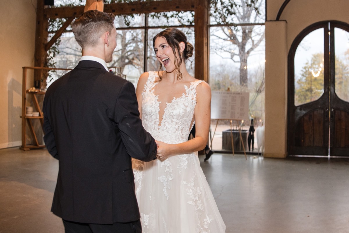 Bride and groom kissing after vows at rainy ceremony.