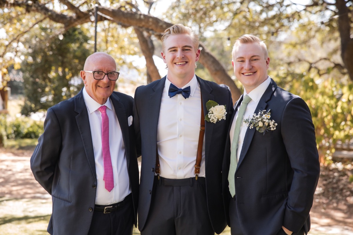 N adjusting groom's boutonniere before Retreat at Balcones Springs ceremony