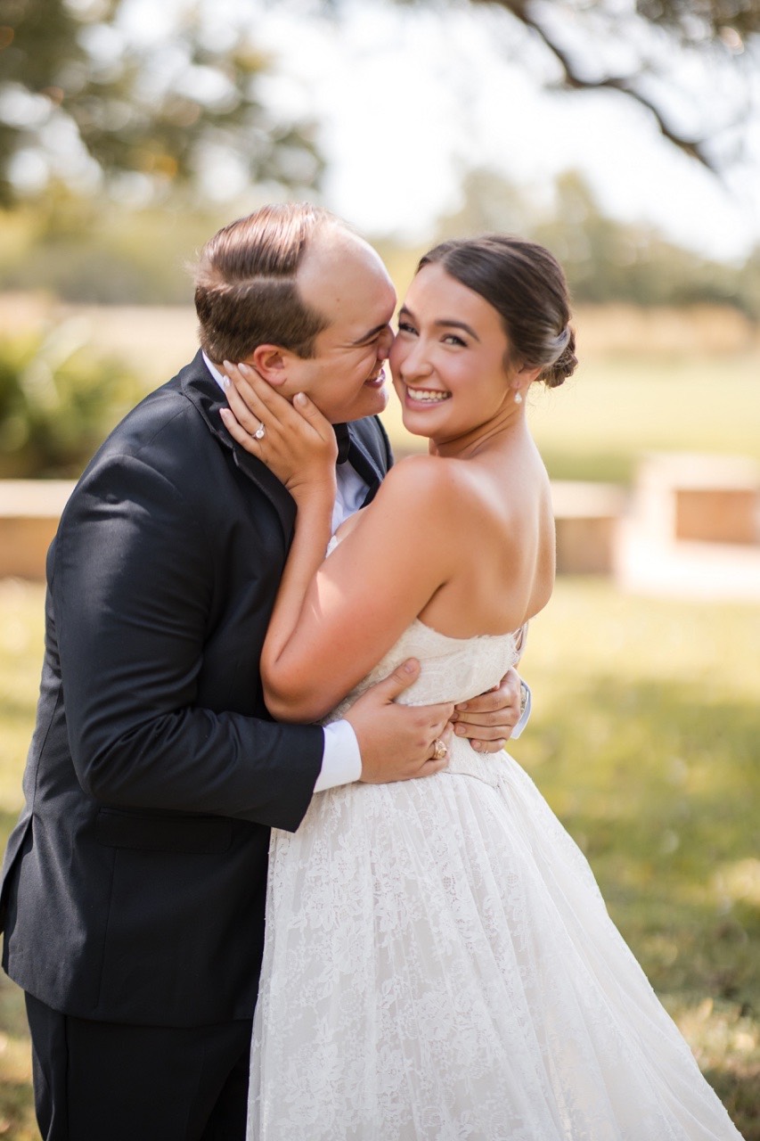 Wedding details including rings and invitations at Pecan Springs Ranch venue
