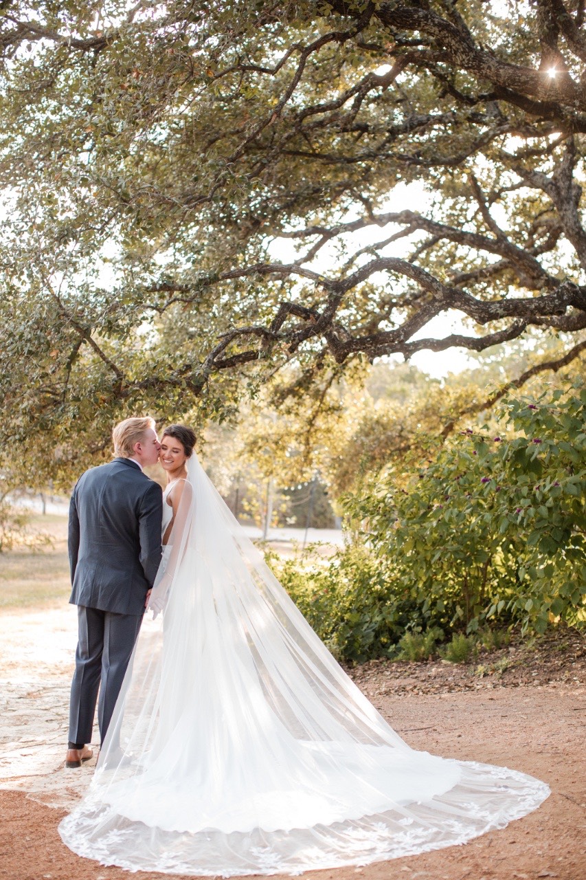 Bride and groom with natural Texas landscape behind them at Marble Falls