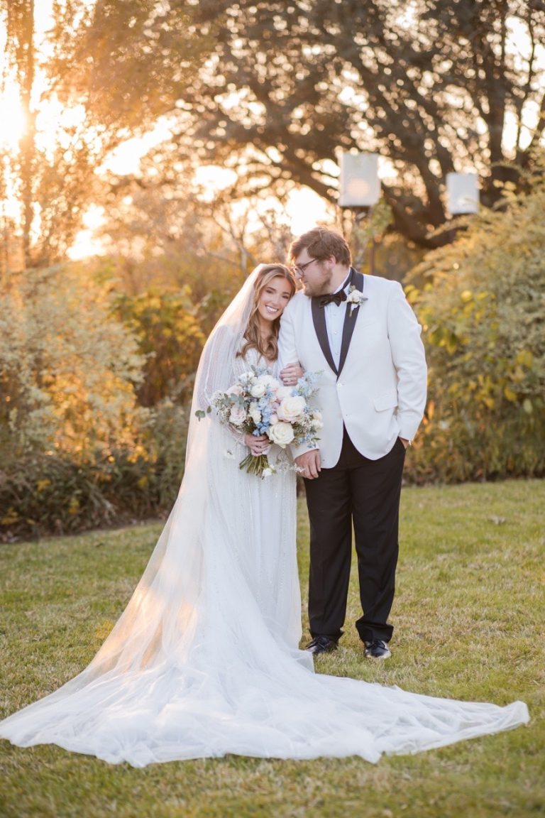 Bride and groom posing by Barr Mansion's historic windows for portraits.