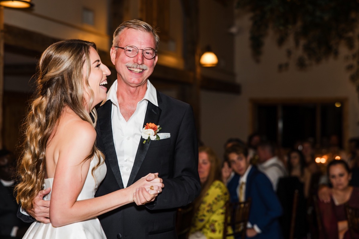 Groom surrounded by dancing guests at Camp Lucy Dripping Springs wedding