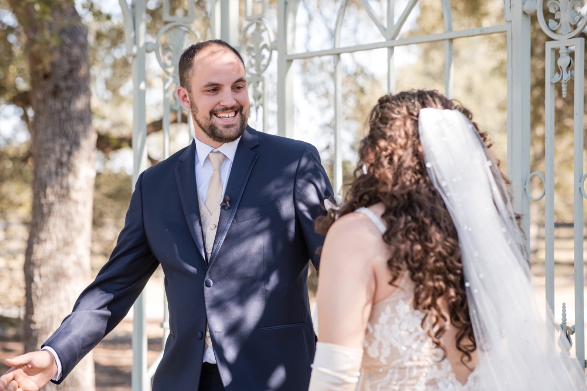 Groom adjusting tie and boutonniere before fall wedding at Ma Maison