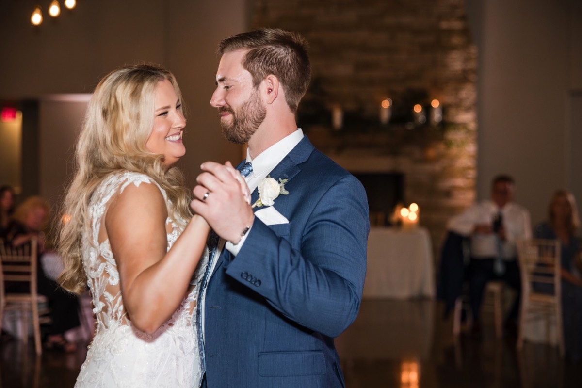 Newlyweds posed against rustic Canyonwood Ridge winter wedding venue backdrop