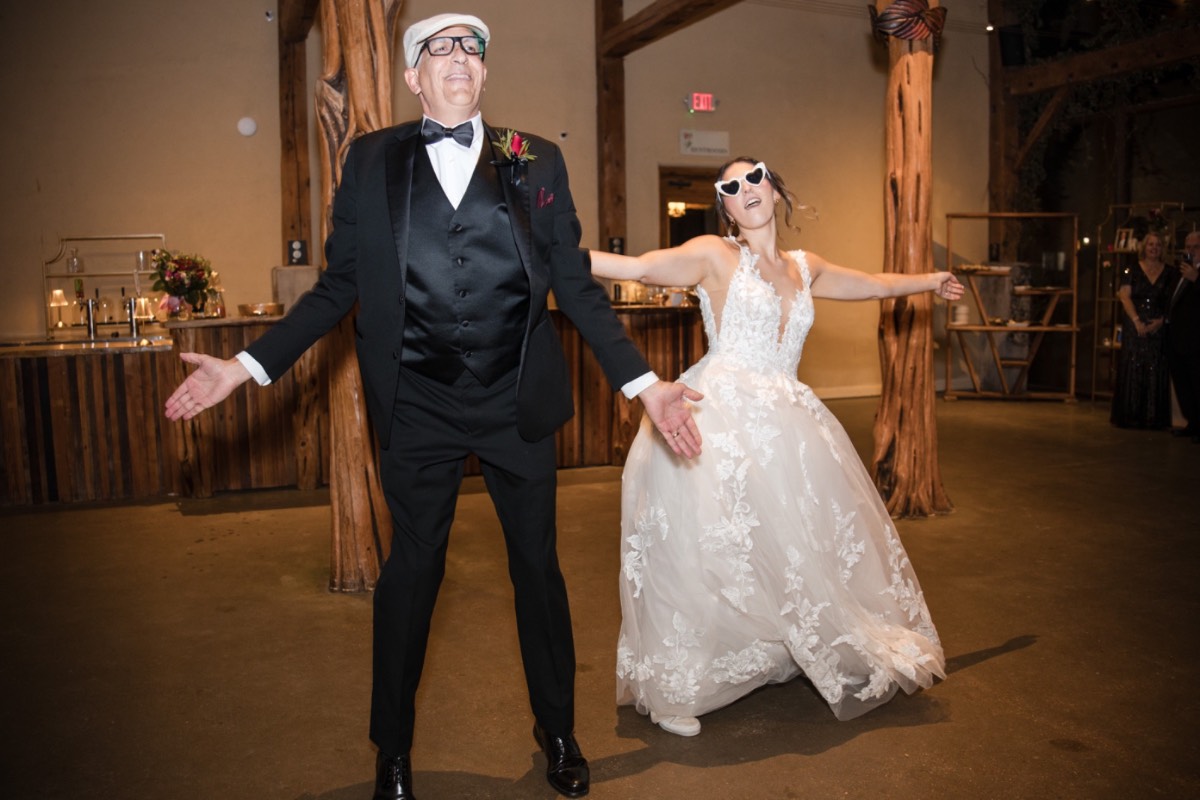 Couple dancing in rain after ceremony at Austin venue.