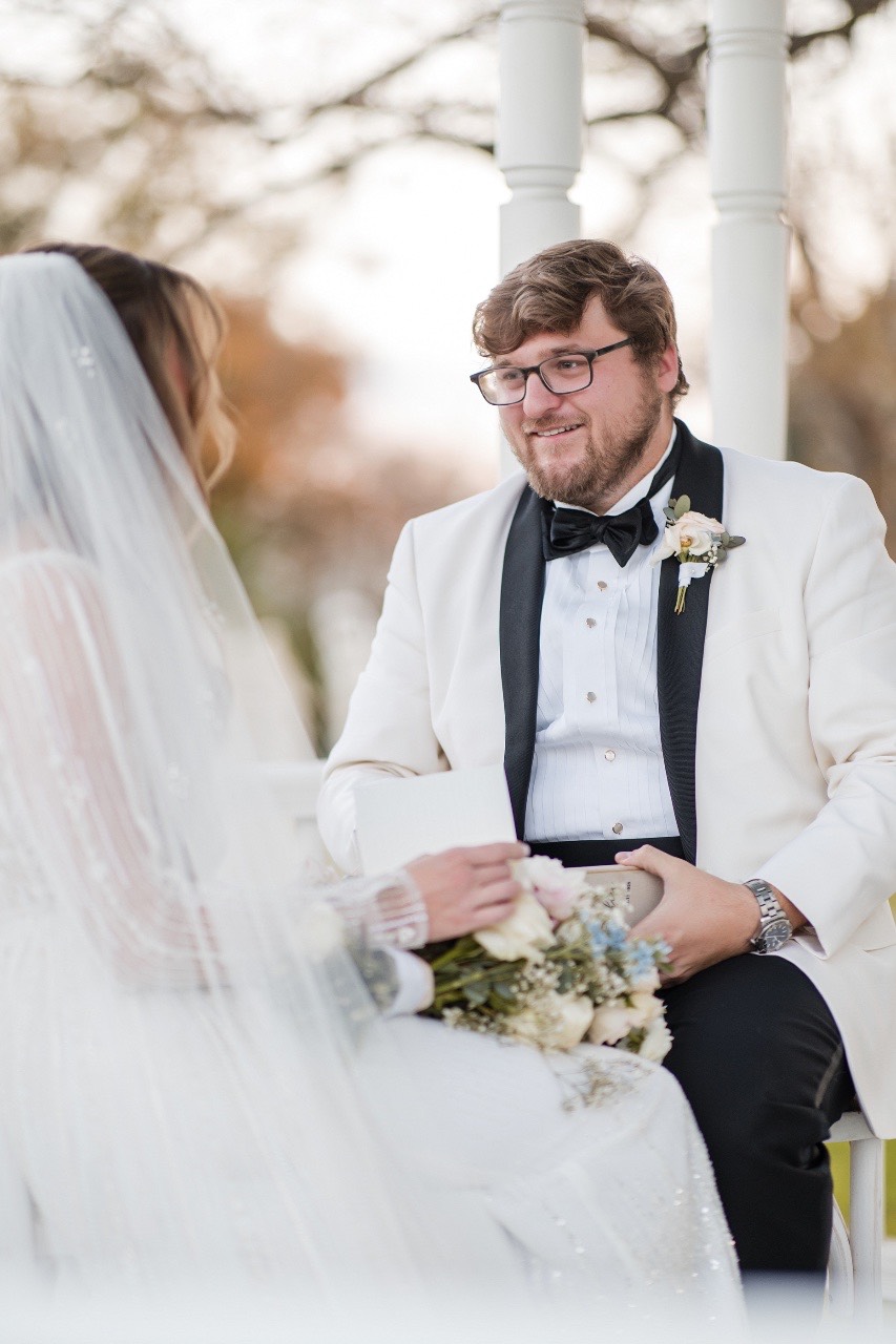 Couple embracing under Barr Mansion's archway for winter wedding portraits.