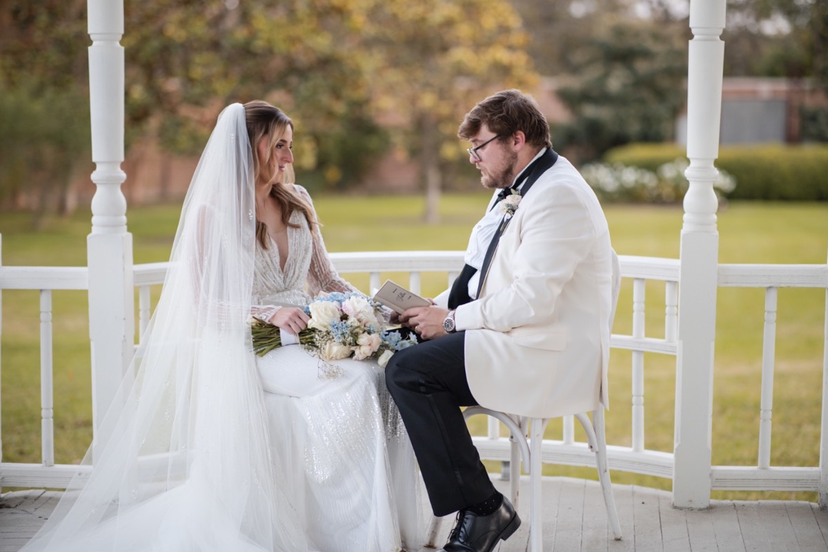 A and S posing by fireplace at Barr Mansion winter wedding Austin.