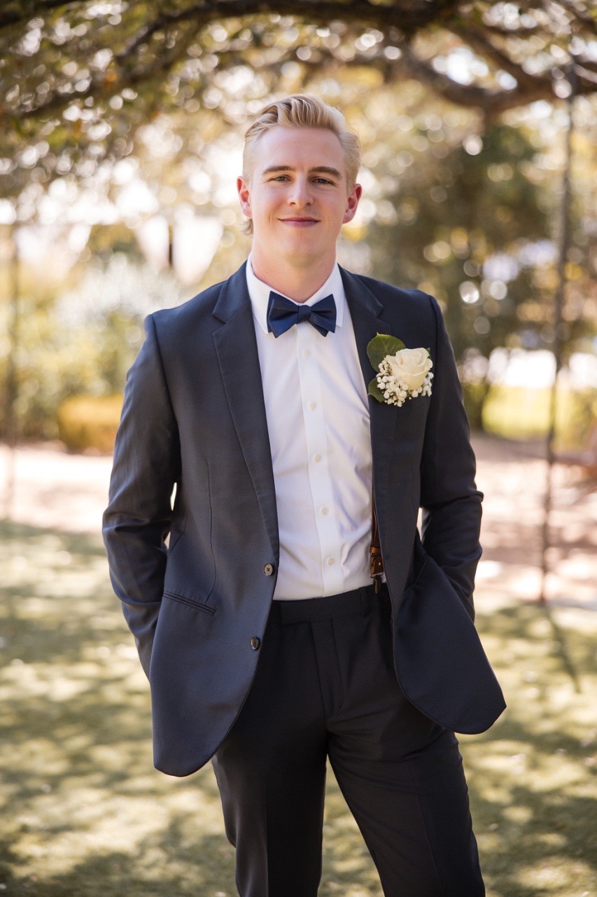 Groom's groomsmen helping with tie at Balcones Springs wedding venue