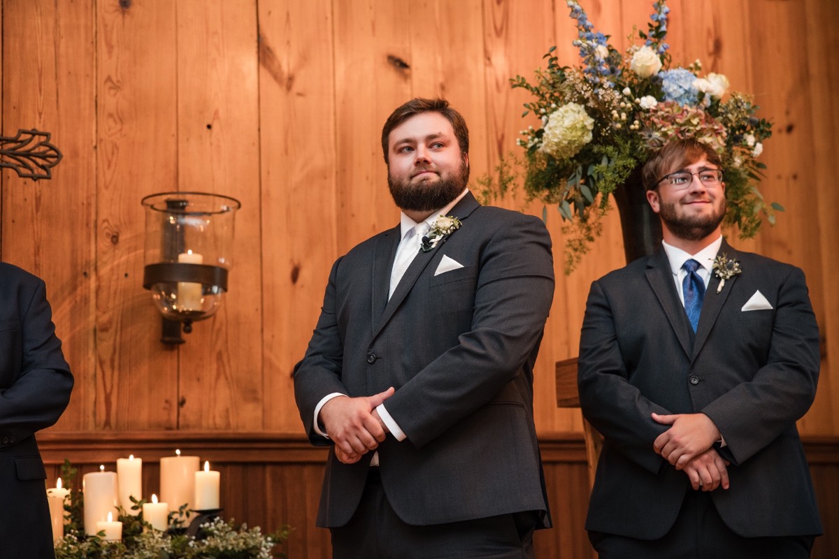 Groom D adjusting boutonniere before Old Glory Ranch wedding in Wimberley