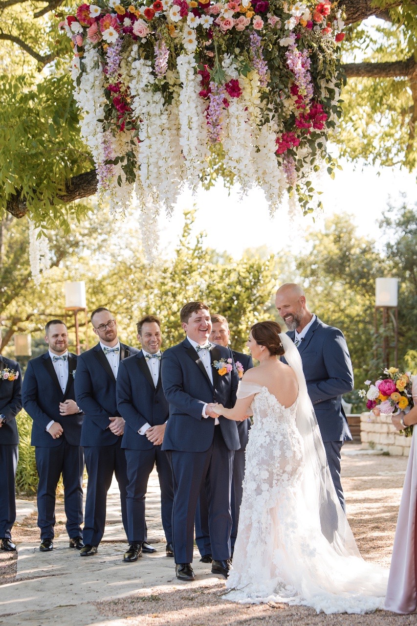 Bride L and groom S holding hands in garden at Barr Mansion