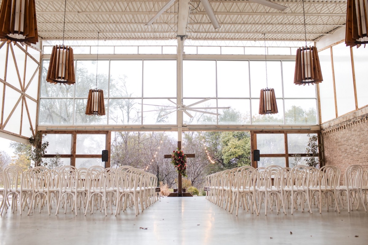 Guests mingling under cover during rainy Barr Mansion wedding.