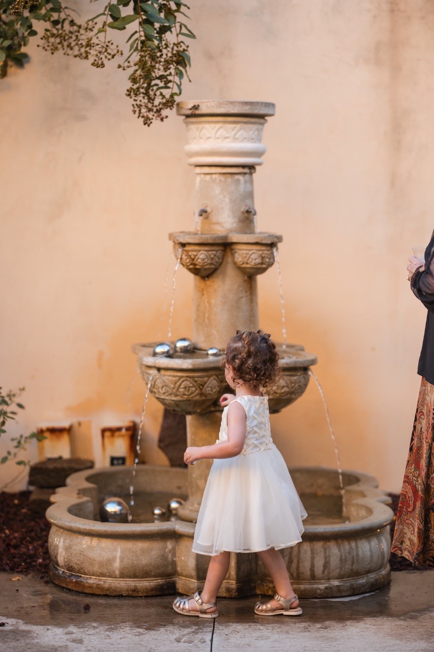 Newlyweds running toward getaway car amid celebration at Dripping Springs venue
